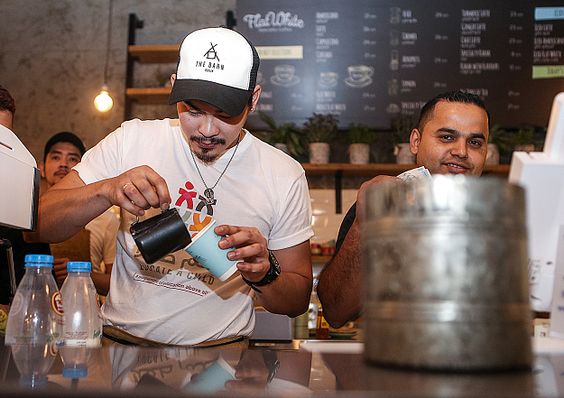 Baristas prepare orders at the