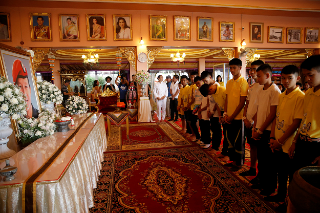 Members of a soccer team rescued from a cave pay respect to former Navy SEAL diver Saman Kunan who died during the rescue operation. PHOTO:REUTERS