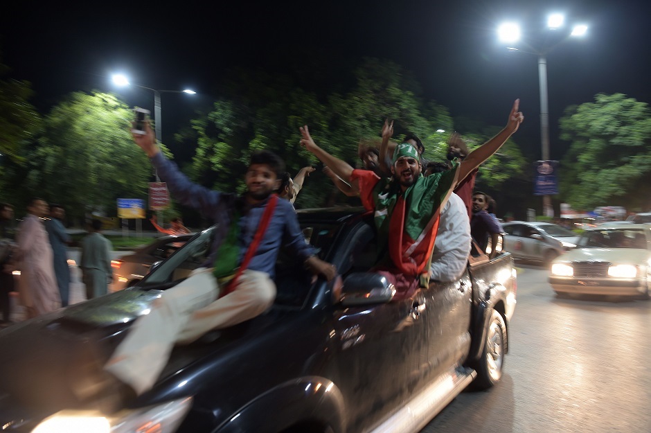 Supporters of Pakistan's cricketer-turned politician Imran Khan, head of the Pakistan Tehreek-e-Insaf (Movement for Justice) party, celebrate on a street during general election in Islamabad on July 25, 2018. Vote-counting was ongoing on July 25 in a knife-edge Pakistan general election as former cricket hero Imran Khan sought power on a day marred by a bloody suicide bombing and claims of military interference. PHOTO: AFP