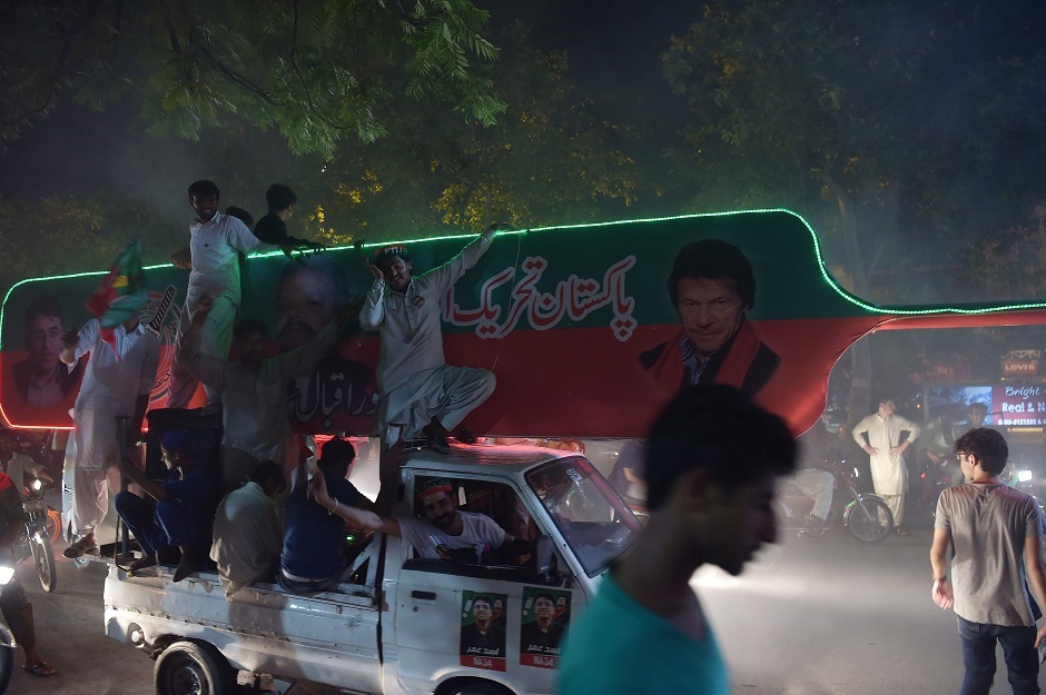 Supporters of Pakistan's cricketer-turned politician Imran Khan, head of the Pakistan Tehreek-e-Insaf (Movement for Justice) party, celebrate on a street during general election in Islamabad on July 25, 2018. Vote-counting was ongoing on July 25 in a knife-edge Pakistan general election as former cricket hero Imran Khan sought power on a day marred by a bloody suicide bombing and claims of military interference. PHOTO:AFP 