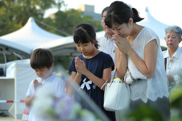 Family members offer prayers for the atomic bomb victims at the Peace Memorial Park in Hiroshima. PHOTO:AFP