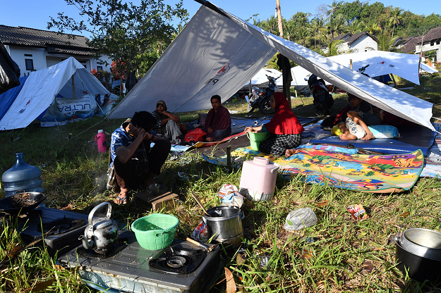 Residents rest in a temporary shelter in Gunung Sari, west Lombok. PHOTO:AFP