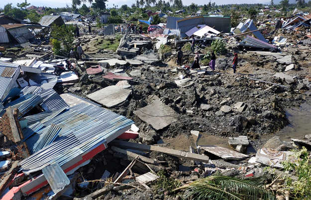  People walk through a residential area after an earthquake and tsunami in Palu. PHOTO: REUTERS