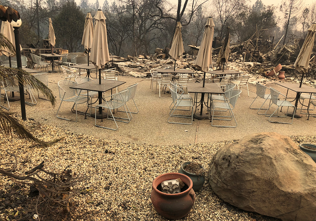 Cafe tables and umbrellas stand idle as the remains of Mama Celeste's Gastropub and Pizzeria lies in ruins after wildfires devastated the area in Paradise. PHOTO: REUTERS