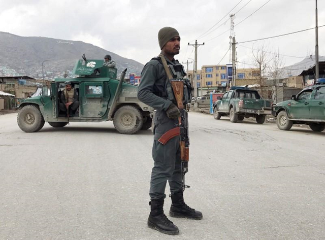 an afghan policeman stands guard near the site of an attack in kabul afghanistan march 25 2020 photo reuters
