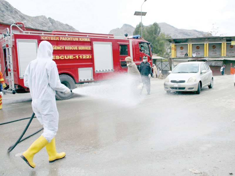 rescue 1122 workers disinfect a road in landikotal khyber district on wednesday to help prevent the coronavirus photo ppi