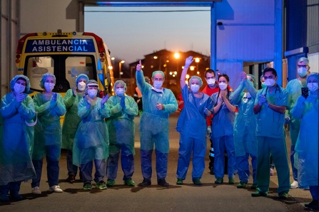 healthcare workers dealing with the new coronavirus crisis applaud in return as they are cheered on by people outside a hospital in burgos spain photo afp
