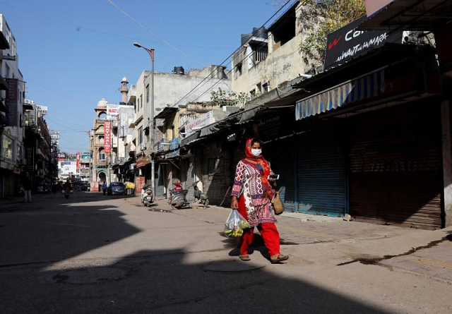 a woman walks along a near empty street during a lockdown amid a coronavirus disease covid 19 outbreak in new delhi india march 25 2020 photo reuters