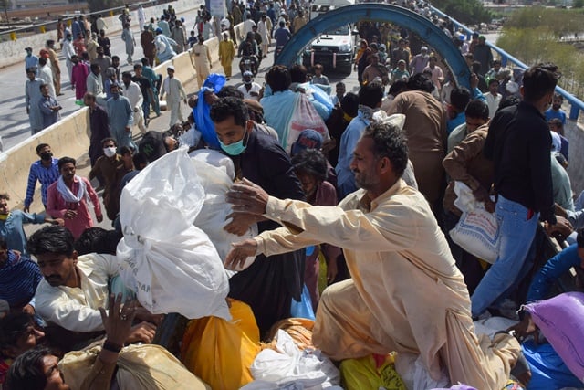 people gather to receive ration handouts from a charity truck during a lockdown after pakistan shut all markets public places and discouraged large gatherings amid an outbreak of coronavirus disease covid 19 in hyderabad pakistan march 30 2020 reuters