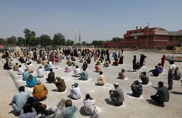 people sit on the ground in circles drawn with chalk to maintain safe distance as they wait to receive sacks of ration handouts from a distribution point of a charity during a partial lockdown after pakistan shut all markets public places and discouraged large gatherings amid an outbreak of coronavirus disease covid 19 in karachi pakistan march 29 2020 reuters akhtar soomro people sit on the ground in circles drawn with chalk to maintain safe distance as they wait to receive sacks of ration handouts from a distribution point of a charity during a partial lockdown after pakistan shut all markets public places and discouraged large gatherings amid an outbreak of coronavirus disease covid 19 in karachi pakistan march 29 2020 reuters akhtar soomro