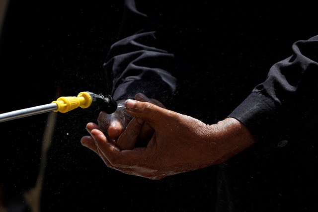 A man disinfects his hands before buying a low-priced food from a charity stall, during a lockdown after Pakistan shut all markets, public places and discouraged large gatherings amid an outbreak of coronavirus disease (COVID-19), in Karach. PHOTO: REUTERS