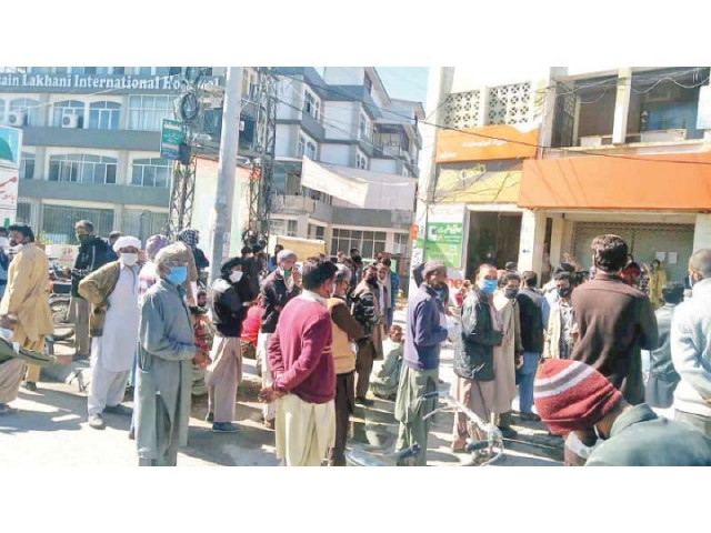 people queue up outside a bank to withdraw their salaries and pensions photo express people queue up outside a bank to withdraw their salaries and pensions photo express