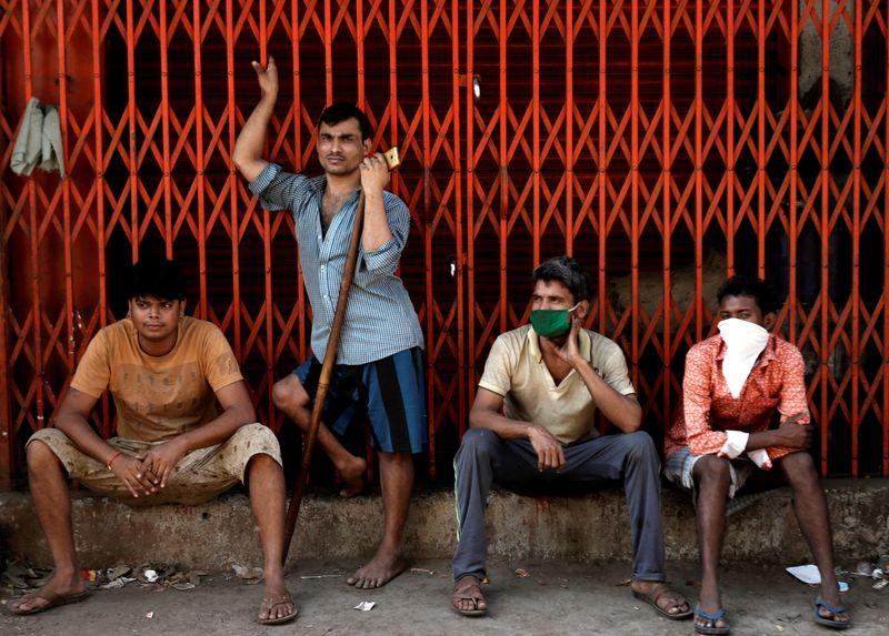 migrant workers who work in textile looms are seen outside a loom after it was shut due to the 21 day nationwide lockdown to slow the spread of the coronavirus disease in bhiwandi on the outskirts of mumbai india april 1 2020 photo reuters