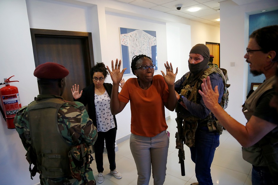 People are evacuated by a member of security forces at the scene where explosions and gunshots were heard at the Dusit hotel compound, in Nairobi, Kenya. PHOTO: REUTERS