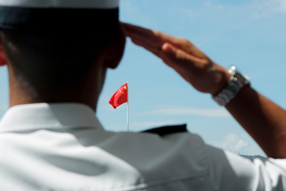 A People's Liberation Army (PLA) soldier saluts to Chinese national flag during an open day of Stonecutters Island naval base, in Hong Kong, China:REUTERS