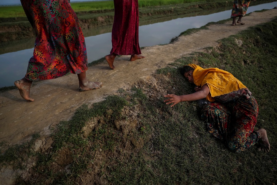 An exhausted Rohingya refugee fleeing violence in Myanmar cries for help from others crossing into Palang Khali, near Cox's Bazar, Bangladesh. PHOTO: REUTERS 