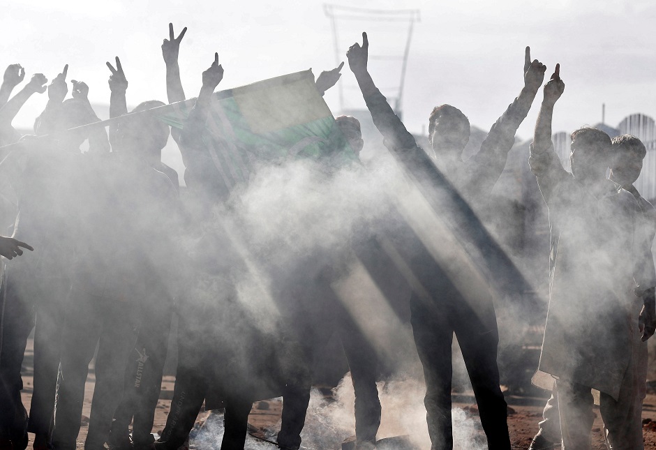 Kashmiris run for cover as a teargas shell fired by Indian security forces explodes during clashes. PHOTO: REUTERS  Kashmiris brave a teargas shell fired by Indian security forces explodes during clashes. PHOTO: REUTERS