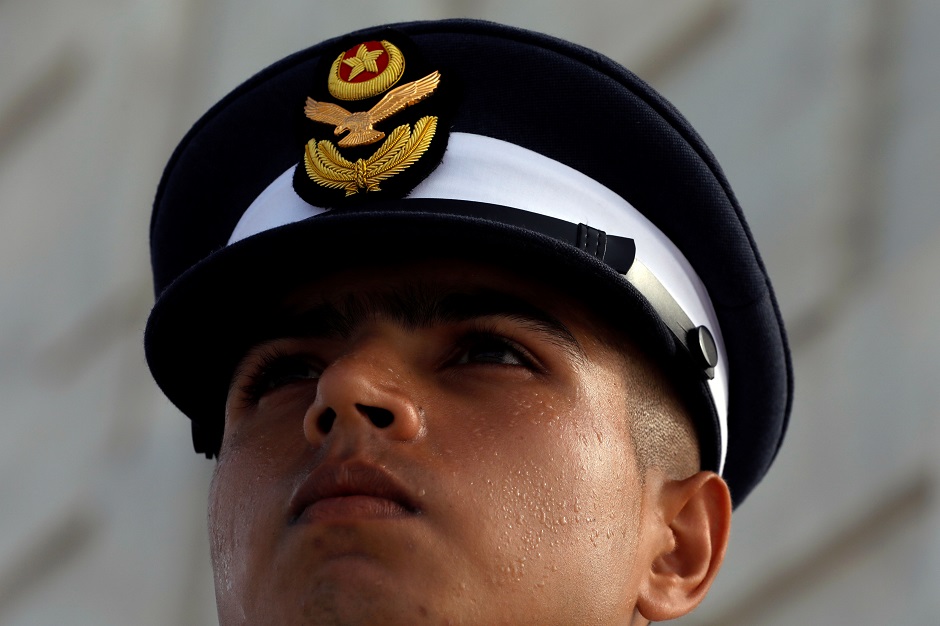 A member of the Pakistan Air Force salutes as the national flag is raised at the mausoleum of Muhammad Ali Jinnah during Defence Day ceremonies. PHOTO : Reuters 