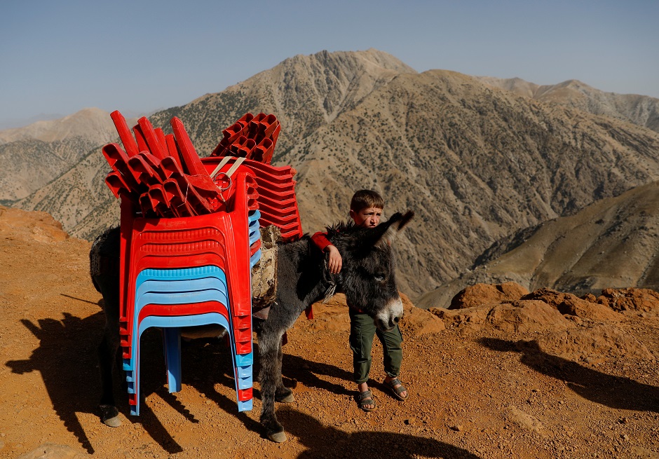 An Afghan boy stands with a donkey loaded election material, to be transported to polling stations which are not accessible by road, on a donkey in Shutul, Panjshir province, Afghanistan. PHOTO: Reuters 