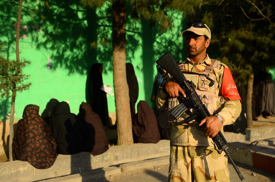 An Afghan security personnel stands guard as women voters wait to cast their ballot at a polling station Herat. PHOTO: AFP