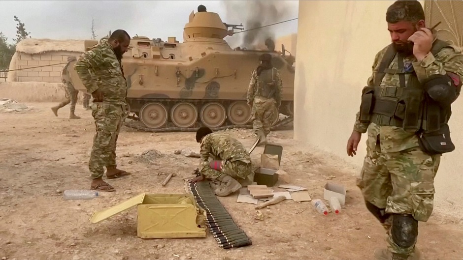 Syrian militants drive a tank through a field near Tal Abyad. PHOTO: REUTERS