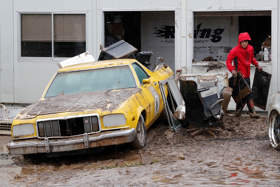 Residents walk in a flooded area. PHOTO: AFP