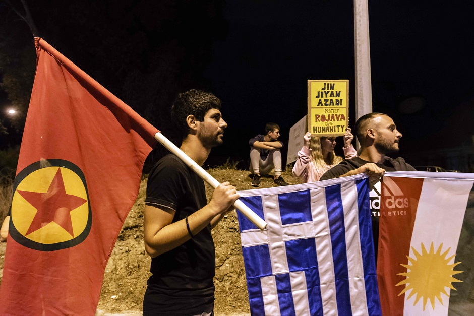 Demonstrators carry the Kurdistan Workers Party (PKK)'s flag, the Greek flag (C) and the Kurdish flag (R) as they march in the Cypriot capital Nicosia. PHOTO: AFP