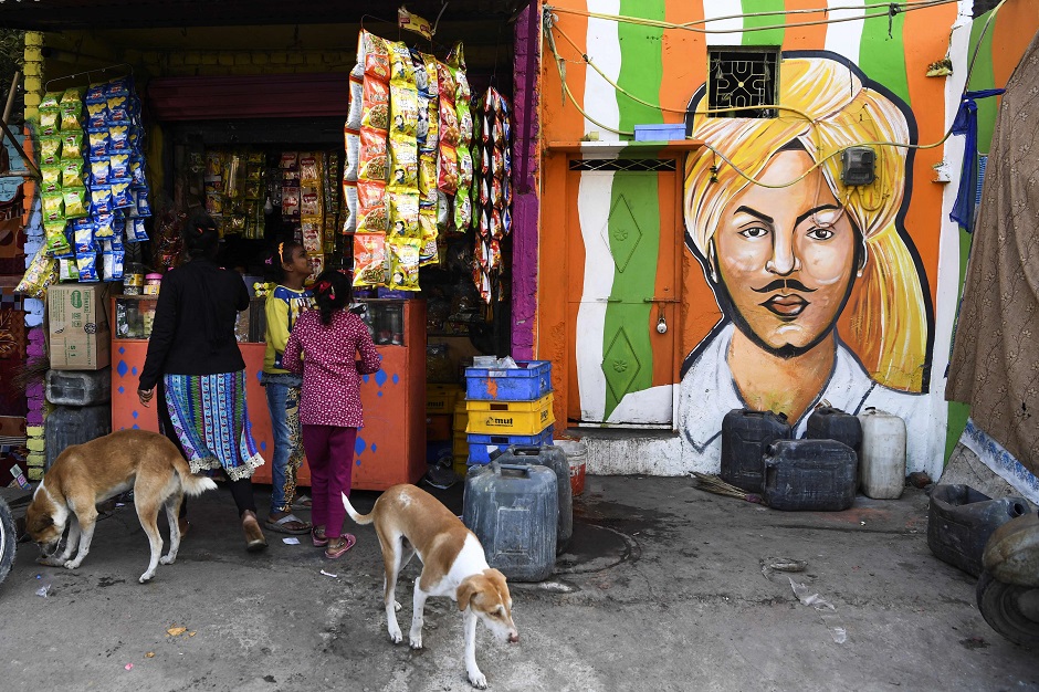 Local residents shop from a store next to a home adorned with a mural painted by artists from 'Delhi Street Art' group at the Raghubir Nagar slum. PHOTO: AFP