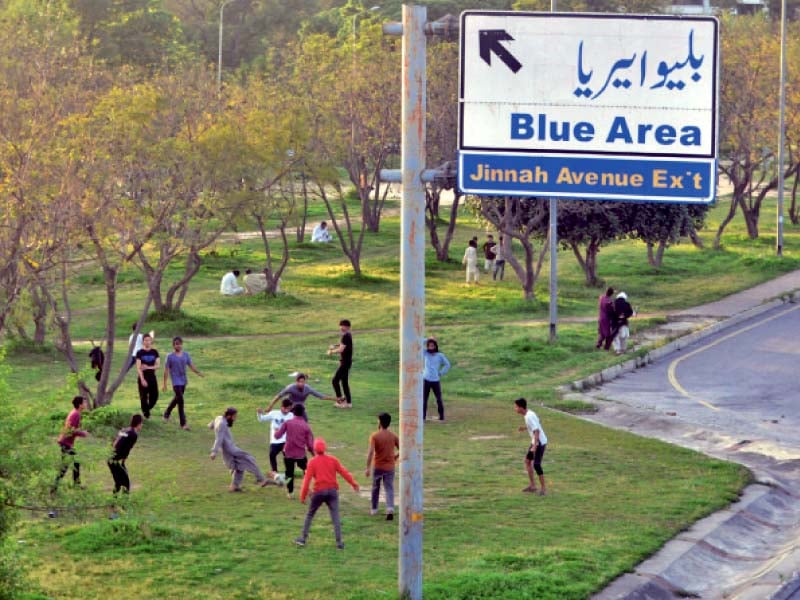 people play football on a greenbelt in islamabad despite a ban on the assembly of more than four individuals photo zafar raja express