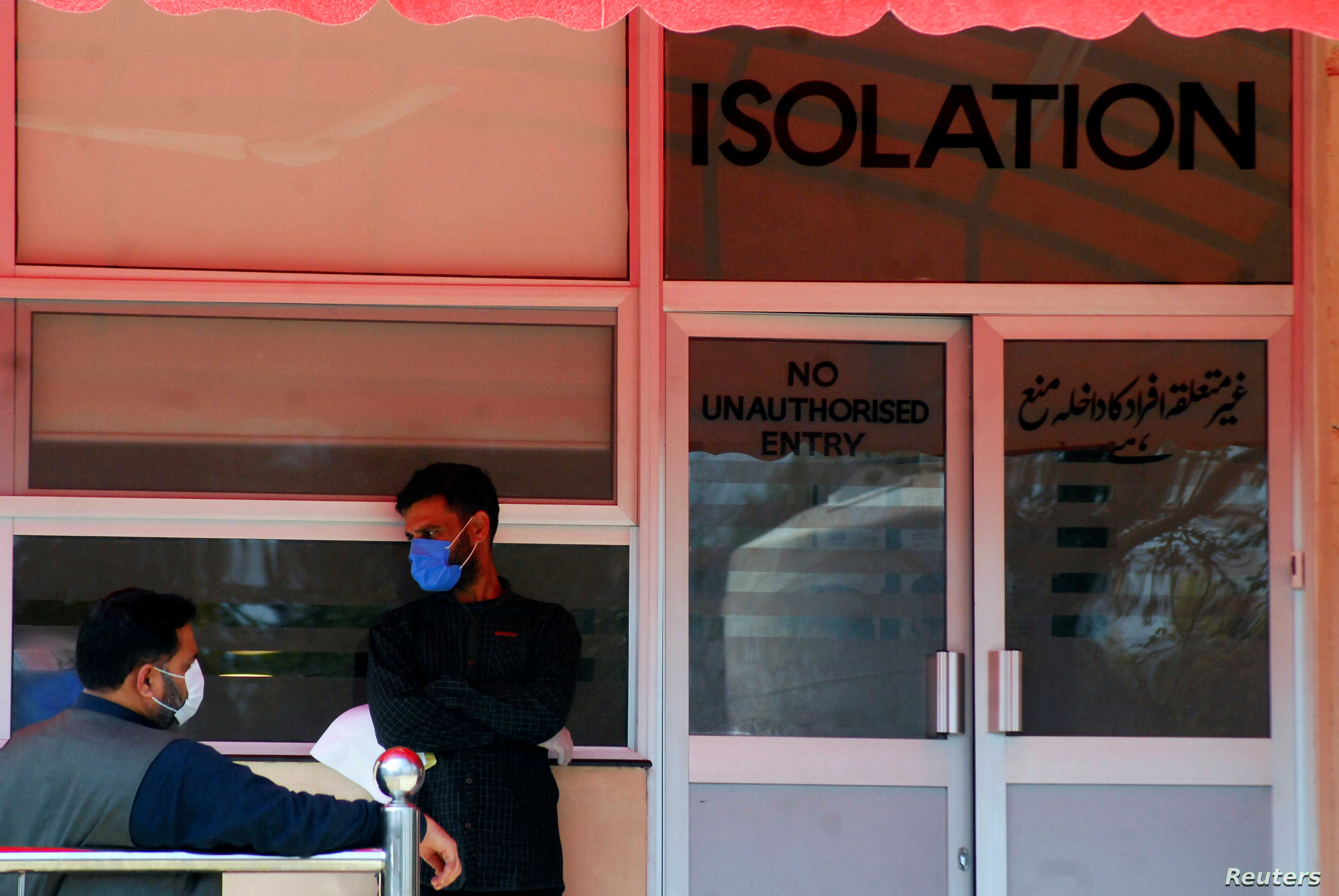 men wear protective mask as a preventive measure against coronavirus as they stand outside the isolation ward at the pakistan institute of medial sciences in islamabad photo reuters