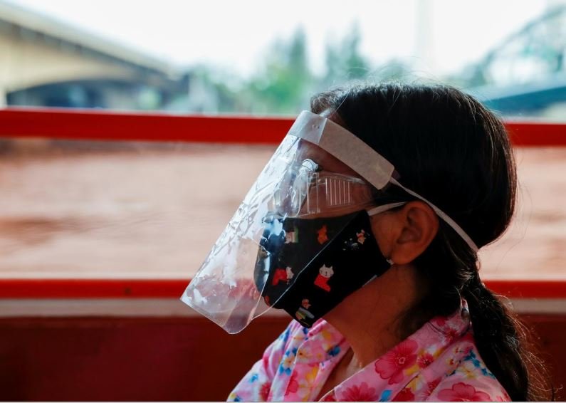 a woman wears a protective face mask while commuting by boat at the chao phraya river during the coronavirus disease covid 19 outbreak in bangkok thailand photo afp