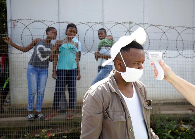 a health worker checks a mans temperature during door to door screening in an attempt to contain the coronavirus disease covid 19 outbreak in jika joe informal settlement in pietermaritzburg south africa april 16 2020 photo reuters