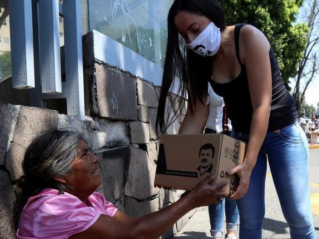 an employee of the clothing brand quot el chapo 701 quot owned by alejandrina gisselle guzman daughter of the convicted drug kingpin joaquin quot el chapo quot guzman hands out a box with food face masks and hand sanitizers to an elderly woman as part of a campaign to help cash strapped elderly people during the coronavirus disease covid 19 outbreak in guadalajara mexico photo reuters