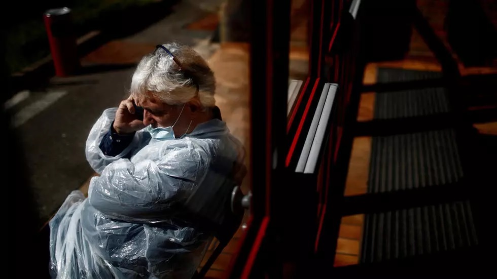 doctor jean no l l pront wearing a protective suit and face mask makes a phone call outside an emergency covid 19 centre in champigny sur marne near paris as the spread of the coronavirus disease continues in france photo reuters