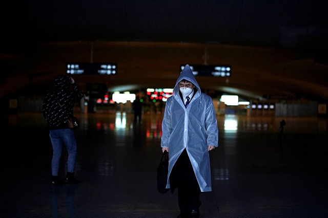 a man wearing a face mask and a plastic raincoat is seen at a railway station of wuhan on the first day of inbound train services resumed following the novel coronavirus disease covid 19 outbreak in wuhan of hubei province the epicentre of china 039 s coronavirus outbreak march 28 2020 photo reuters