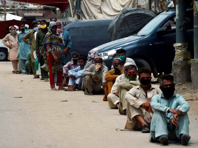 people wait in a line to collect cash from a bank under the government 039 s ehsaas emergency cash programme for families in need during a nationwide lockdown as a preventive measure against the spread of the covid 19 coronavirus in karachi photo afp file
