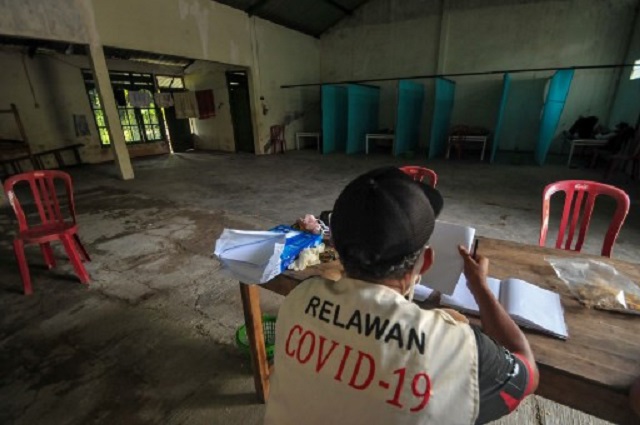 a volunteer keeps watch at a quarantine facility a re0purposed abandoned house believed by some locals to be haunted and used as a deterrent effect against those breaking social restrictions amid the covid 19 coronavirus pandemic at sepat village in sragen central java on tuesday   fed up with people violating coronavirus quarantines one indonesian politician has decided to scare rulebreakers straight by locking them in a 039 haunted house 039 photo afp