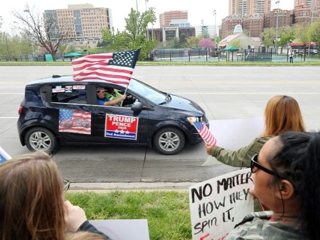 a supporter of president donald trump in kansas city missouri waves an american flag during a protest against restrictions imposed on businesses to fight the covid 19 pandemic photo afp