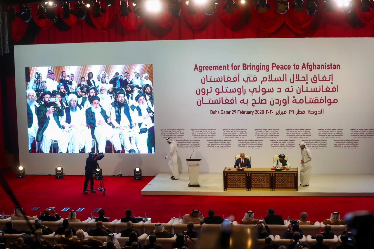 mullah abdul ghani baradar the leader of the taliban delegation signs an agreement with zalmay khalilzad us envoy for peace in afghanistan at a signing agreement ceremony between members of afghanistan 039 s taliban and the us in doha qatar february 29 2020 photo reuters