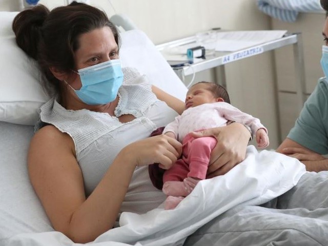 amandine who tested positive for the coronavirus disease covid 19 just before giving birth wearing protective face mask is pictured with her newborn daughter mahaut at the maternity at chirec delta hospital in brussels photo reuters