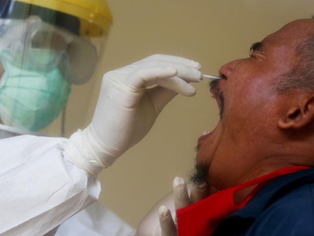 a health worker performs a coronavirus disease covid 19 nasal swab test on a man in depok on the outskirts of jakarta during the outbreak of the coronavirus disease covid 19 indonesia photo reuters file