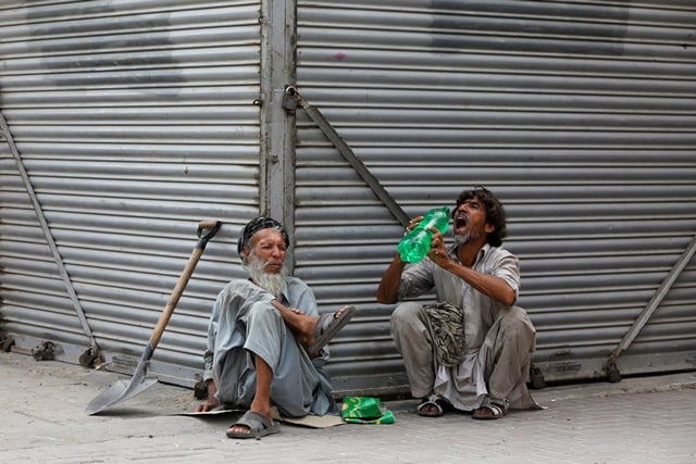 daily wage laborers wait for work as they sit outside closed shops during lockdown amid the outbreak of coronavirus disease at a market in karachi pakistan april 14 2020 reuters