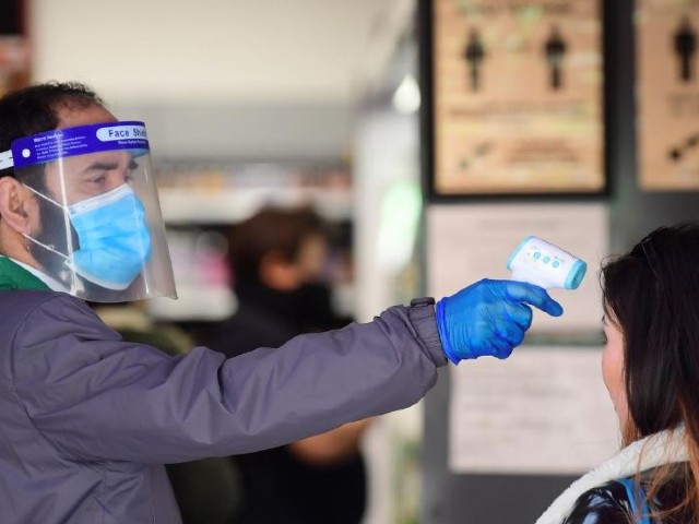 an employee takes the temperature of a customer at the entrance of a super market in china town in london following the outbreak of the coronavirus disease covid 19 london britain photo reuters file