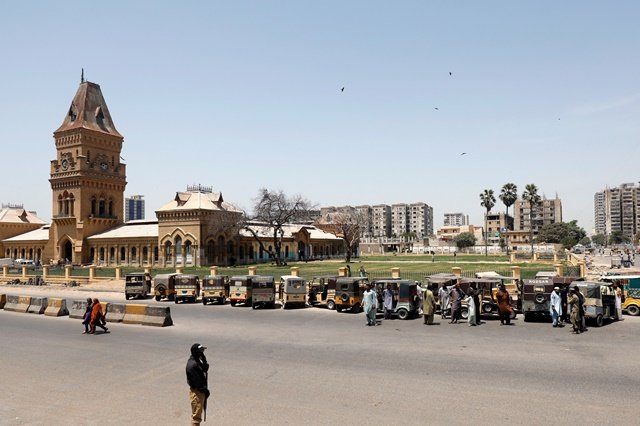 a police officer stands guard in front of drivers and their rickshaws tuk tuk which were stopped for not providing valid reasons to travel during a lockdown following the spread of the coronavirus disease covid 19 in karachi pakistan april 9 2020 photo reuters