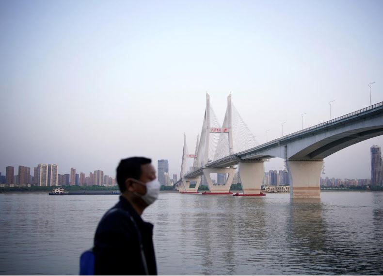 a man wearing a face mask is seen under a bridge of yangtze river in wuhan after the lockdown was lifted in wuhan capital of hubei province and china 039 s epicentre of the novel coronavirus disease covid 19 outbreak photo reuters