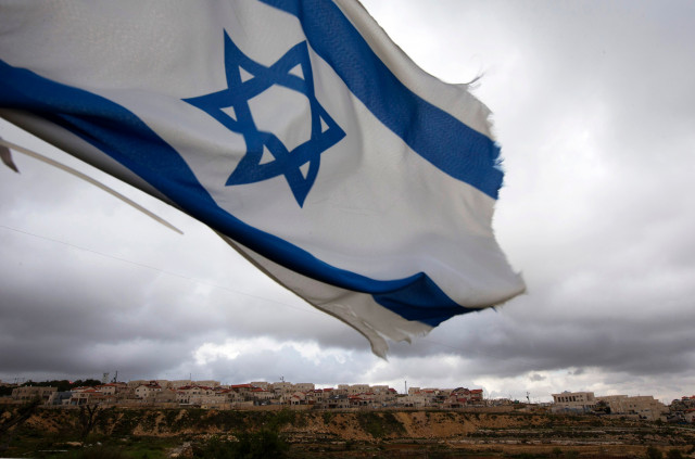 an israeli flag flies on a hill near the west bank photo reuters