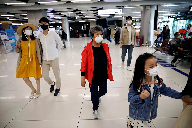 people wearing masks to avoid the spread of the coronavirus disease covid 19 arrive at gimpo international airport in seoul south korea may 1 2020 photo reuters