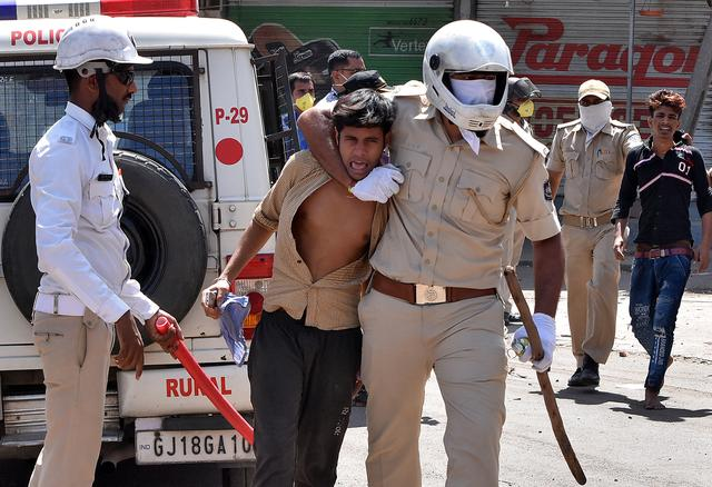 police officers detain men during a protest by migrant workers demanding to return to their home states in surat photo reuters file