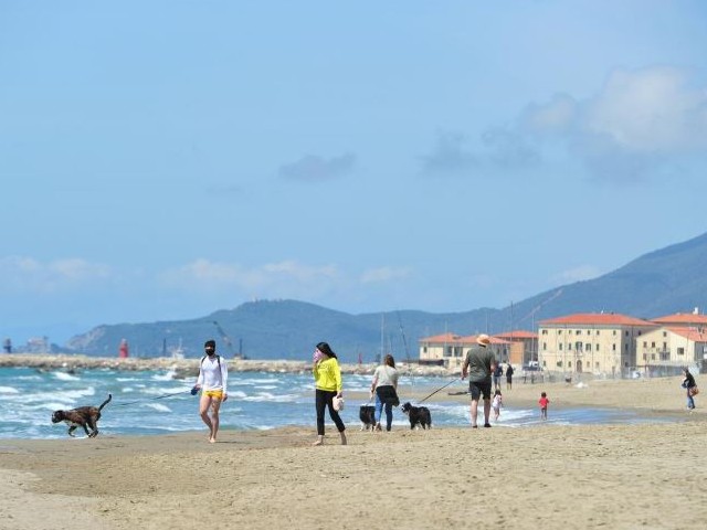 people walk along the beach as italy begins to ease some of the restrictions of the coronavirus disease covid 19 lockdown in castiglione della pescaia italy photo reuters