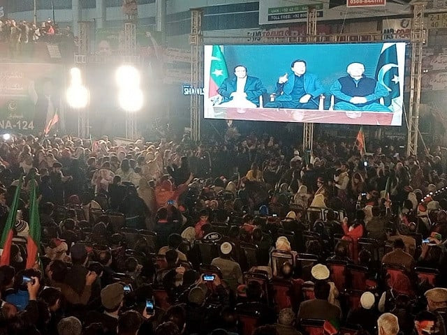 pti chief imran khan flanked by the punjab and k p chief ministers addresses party supporters via video link in lahore photo nni